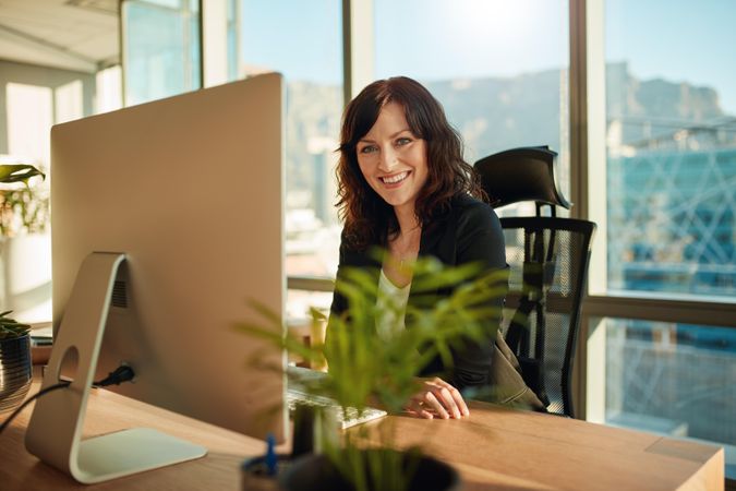 Female CEO sitting at her desk and smiling