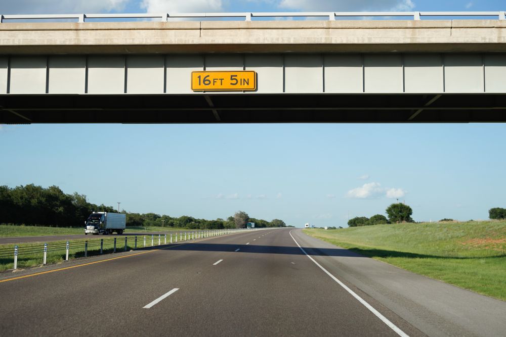 Bridge above road with height mentioned on board