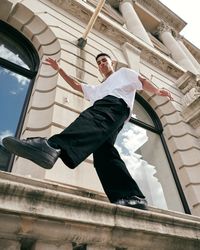 Man walking in an exaggerated pose on stoop in London