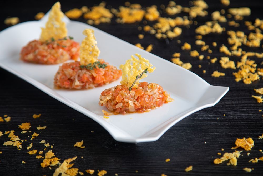 Tasty Quenelles of tomato fondue and Parmensan tile in ornamental plate