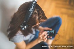 Top view of a woman wearing headphones and using smartphone 48Q9vb
