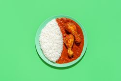 Rice and chicken stew dish, above view on a green background