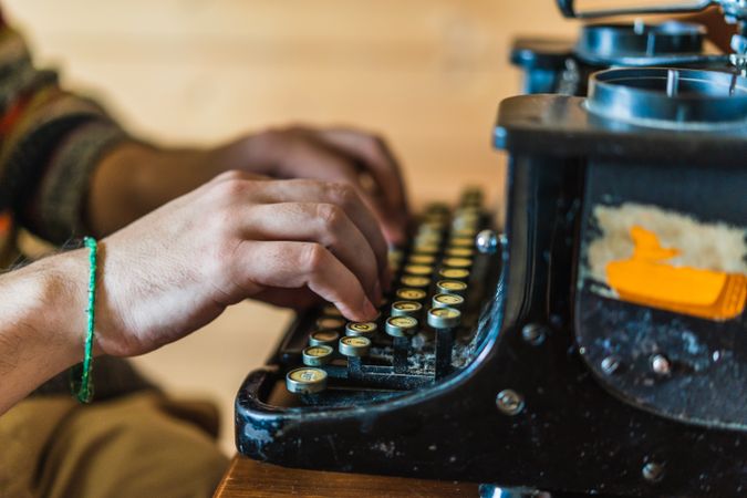 Anonymous man working on a typewriter at home
