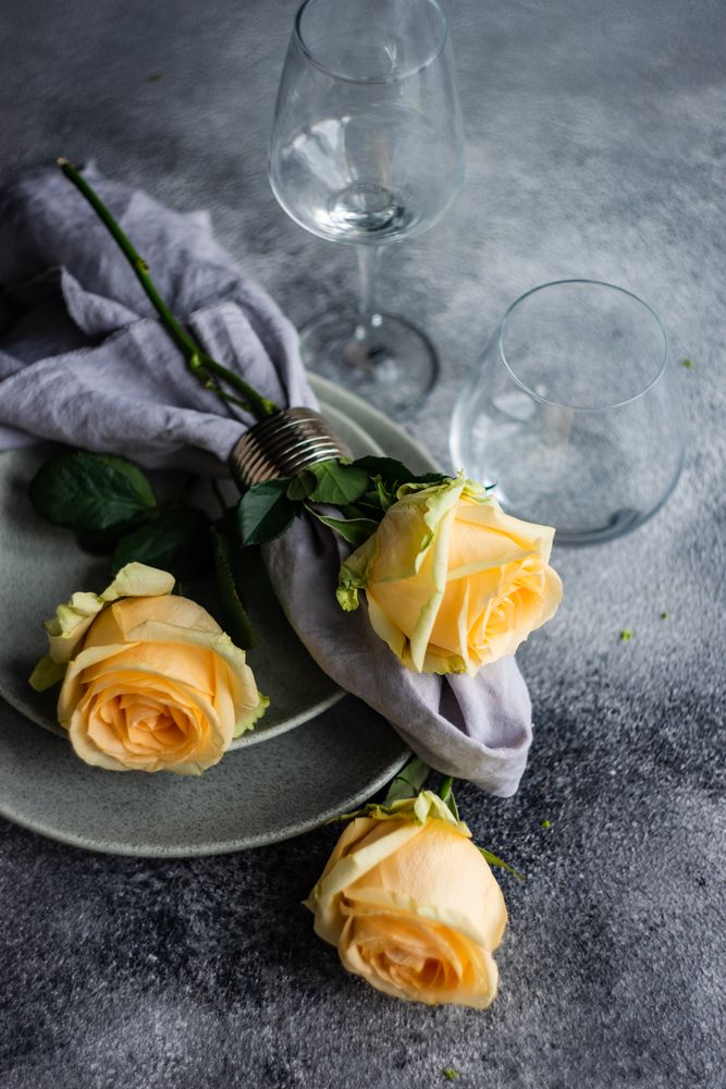 Floral card with yellow flowers scattered on grey table setting