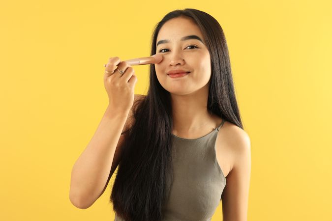 Portrait of Attractive Young Asian Woman with Face Holding Brush for Make Up.