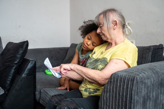 Older woman and grandchild hanging out on sofa