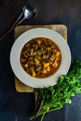 Top view of Georgian meat and vegetable dish Souzi served with cilantro, with copy space