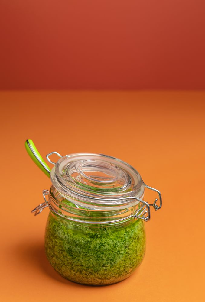 Green pesto sauce in a glass jar