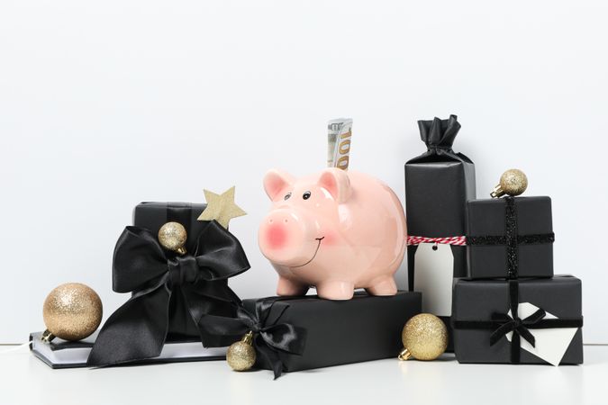 Piggy bank, balls and gift boxes on light background