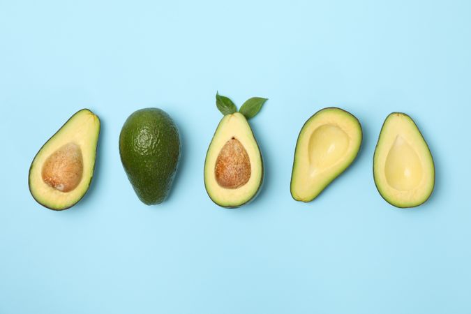 Ripe fresh avocado on blue background, top view