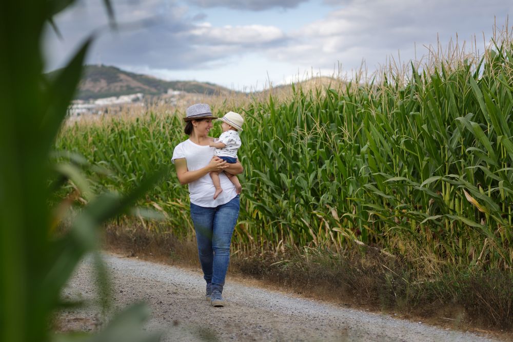 Adorable mother and child on hand enjoying and laughing in field