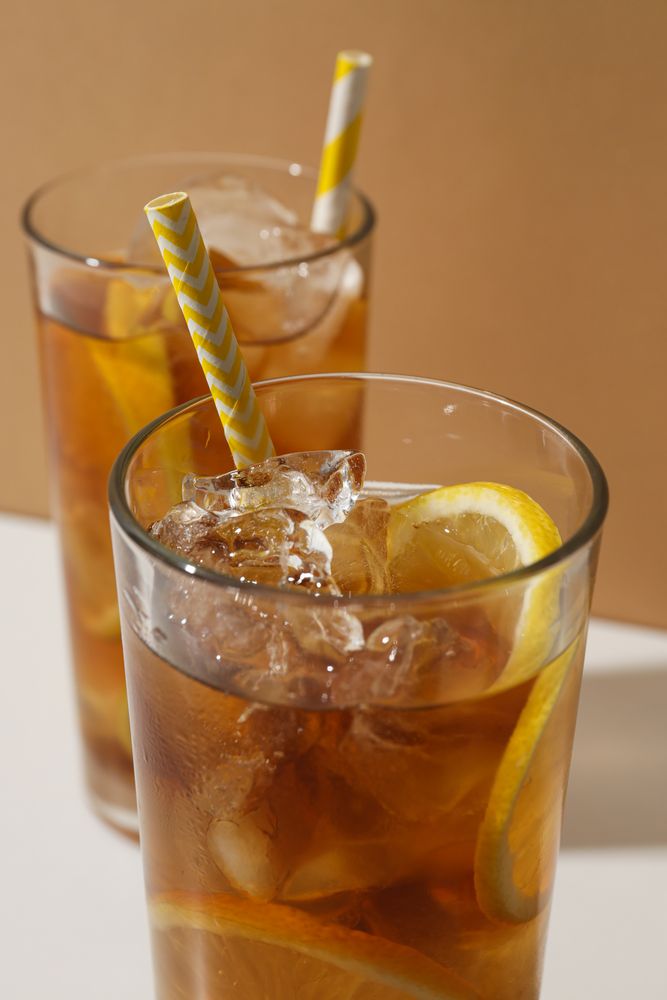 Glasses of cold tea with an orange