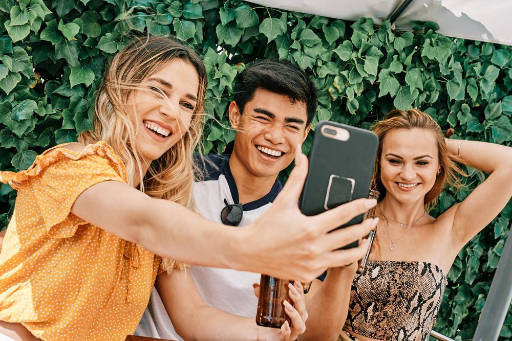 a group of young people making a selfie with last generation mobile phone
