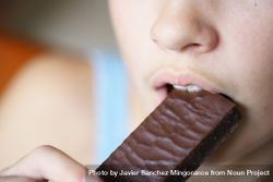 Girl biting into chocolate bar 4mWDLB