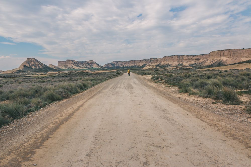 Man standing on road in desert hills
