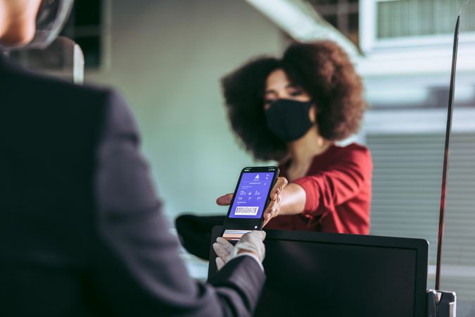 Woman wearing facemask with digital boarding pass