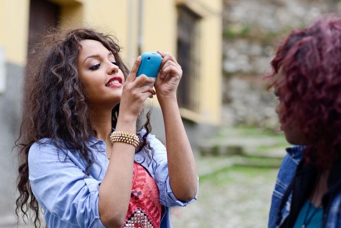 Black female taking a picture of her friend with her camera phone