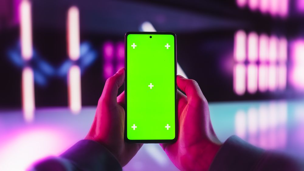 Anonymous Gamer Holding Smartphone Vertically with Green Screen Mock Up Display, Browsing Social Content. Template for Digital Presentations, App and Software Design, Creative Communication