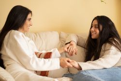 Mother and daughter smiling and holding hands