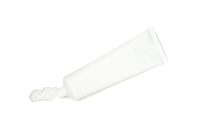 Blank tube with toothpaste isolated on light background