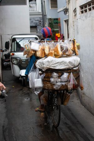 Street vendor riding a bike with baked goods