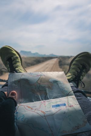 Man in car studying road map driving on road