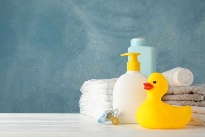 Baby hygiene accessories on wooden table against blue background