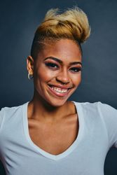 Joyful Black woman with short blonde hair in gray studio