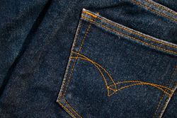 Close up Back pocket of navy blue jeans fabric texture background