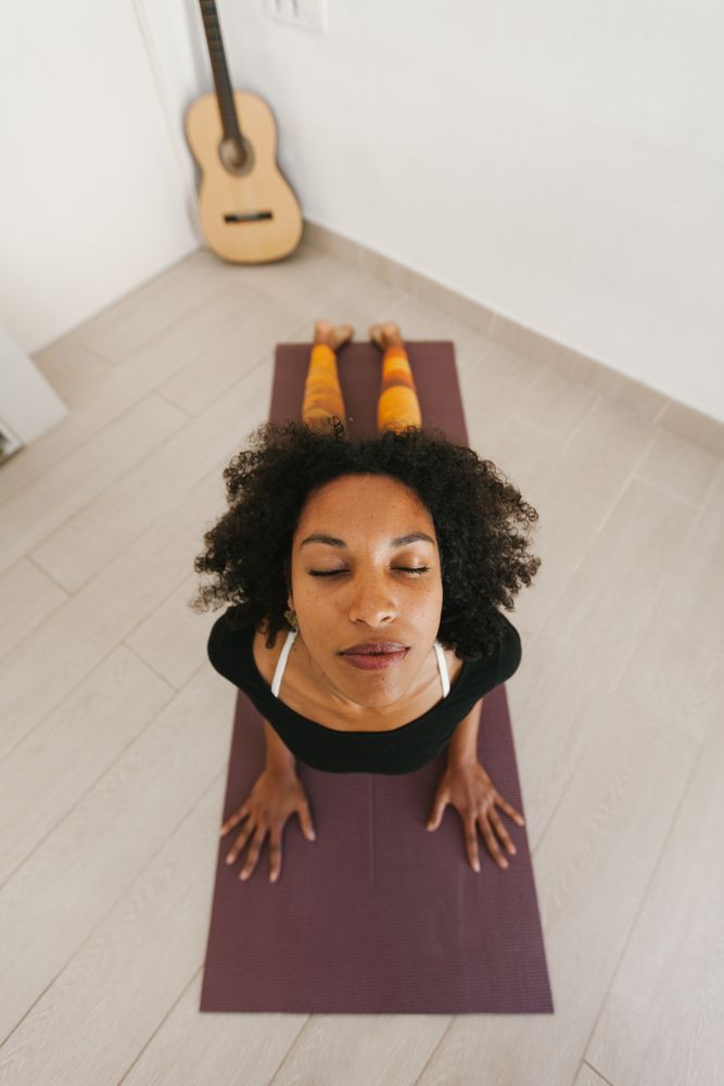 Sportive woman performing yoga pose in room