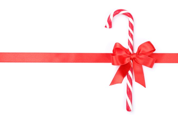 Sweet candy cane with bow isolated on blank background