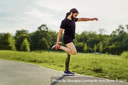 Athletic man with disability - a prosthetic leg - stretching before his workout outdoors in the park bxAzjX