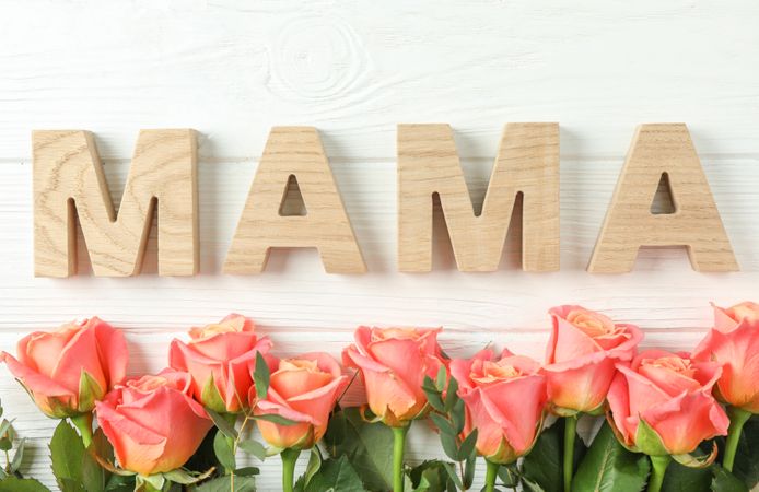 Beautiful orange roses and inscription Mama on bright background, space for text