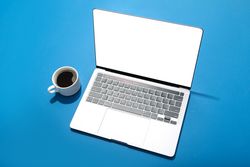 Looking down at blue room with laptop with mock up screen with cup of coffee