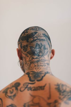 Close-up of tattoos on back of neck of young shaved-head man