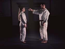 Man pointing gun to head of woman on training