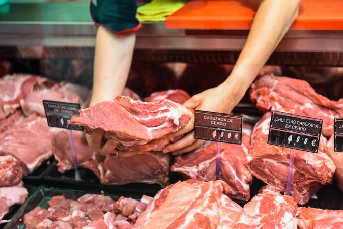 Butcher taking meat from display