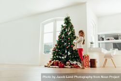 Little girl standing near Christmas tree at home 49m68L