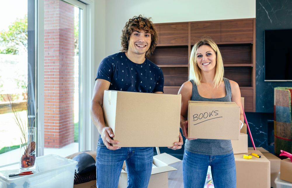 Couple carrying moving boxes