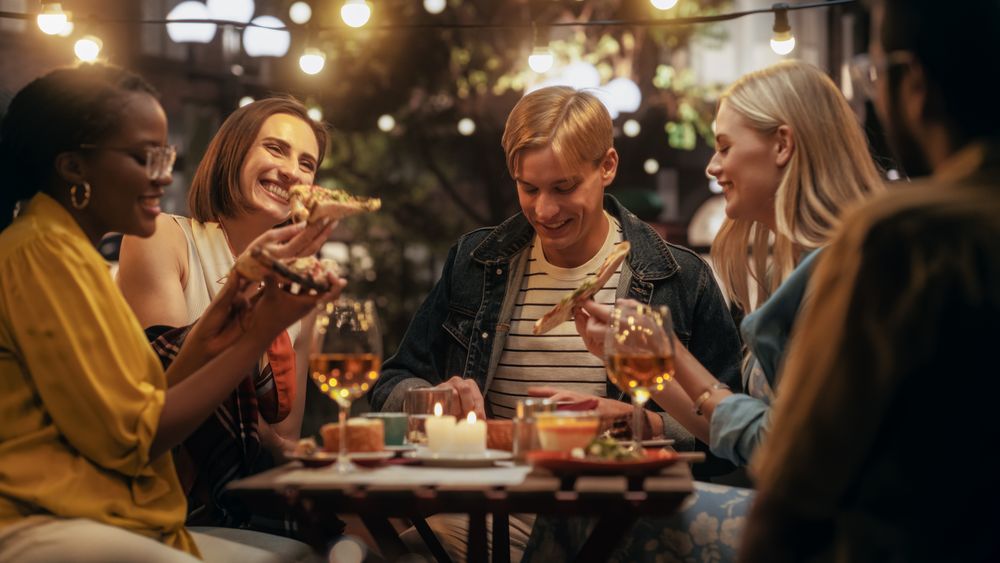 Young Multiethnic Friends Enjoying a Night Out in a Cafe.