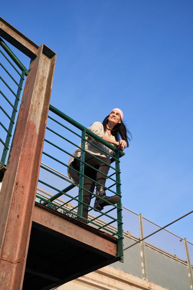 Smiling woman in pink scarf on grunge balcony