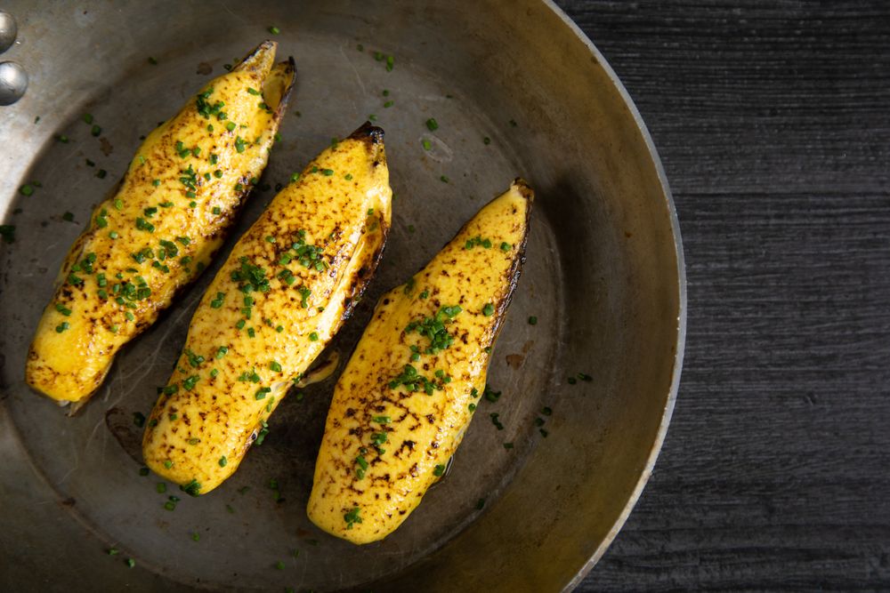 Endives with hollandaise sauce au gratin in pan on table
