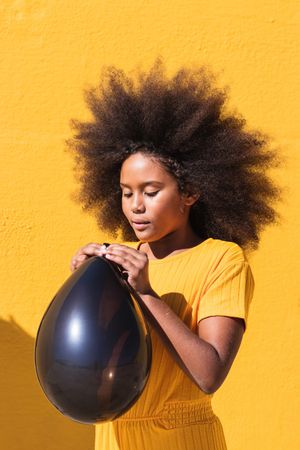 Black girl blowing party balloon