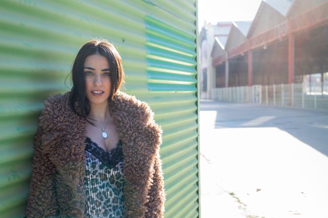 Stylish female near green wall