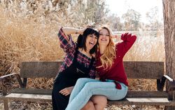 Young women sitting on bench and looking at camera