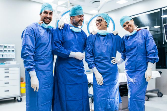 Portrait of successful surgeon team standing in operating room