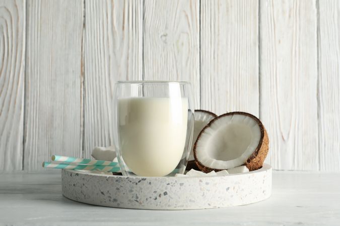 Tray with coconut and milk on wooden background. Tropical fruit