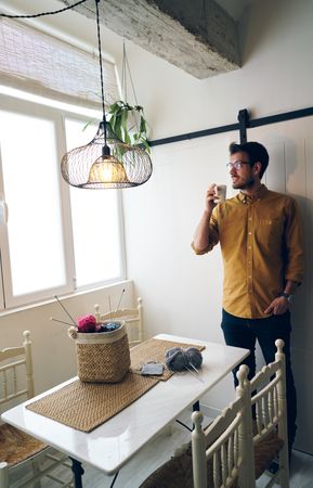 Man drinking hot tea during knitting