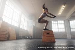 Side view image of fit young woman doing a box jump exercise 492G6b