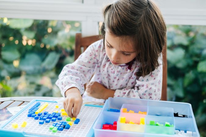 Girl playing with mosaic board game